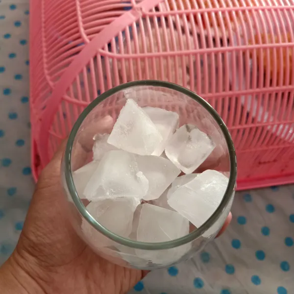 Siapkan es batu dalam gelas saji.