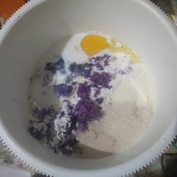 Campurkan tepung terigu, ubi ungu, telur, gula pasir, ragi, susu bubuk dan susu cair. Aduk rata.