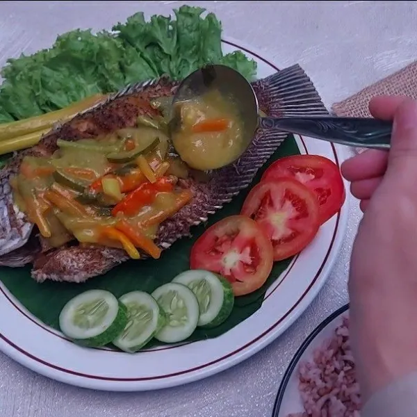 Penyajian : Tata ikan goreng doatas piring saji lalu siram dengan kuah acar kuning.