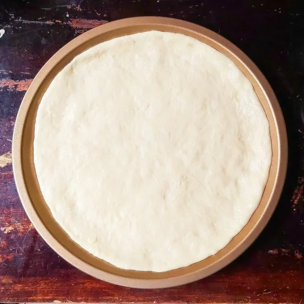 Cetak adonan pada loyang pizza agar lebih rapih, namun bila tidak ada juga tidak apa-apa. Tusuk-tusuk menggunakan garpu.