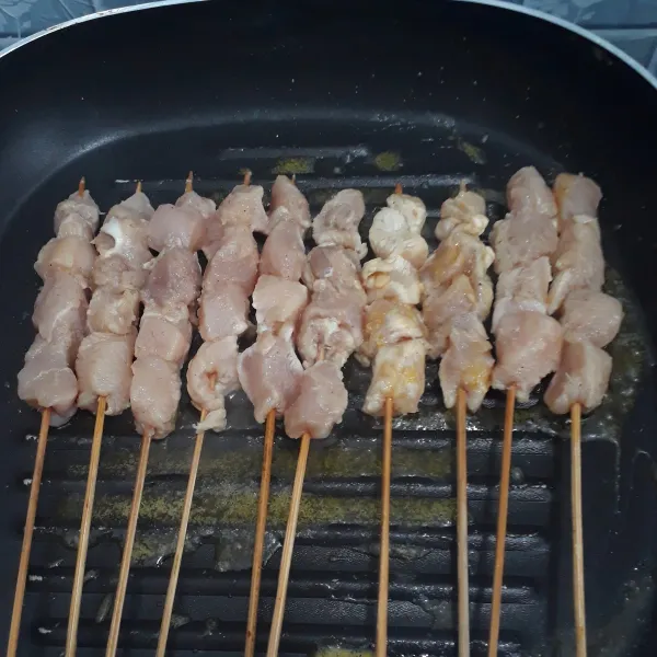Panggangan teflon diolesi minyak goreng lalu panggang sate sambil dibolak balik hingga matang.