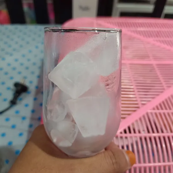 Masukkan es batu dalam gelas saji.