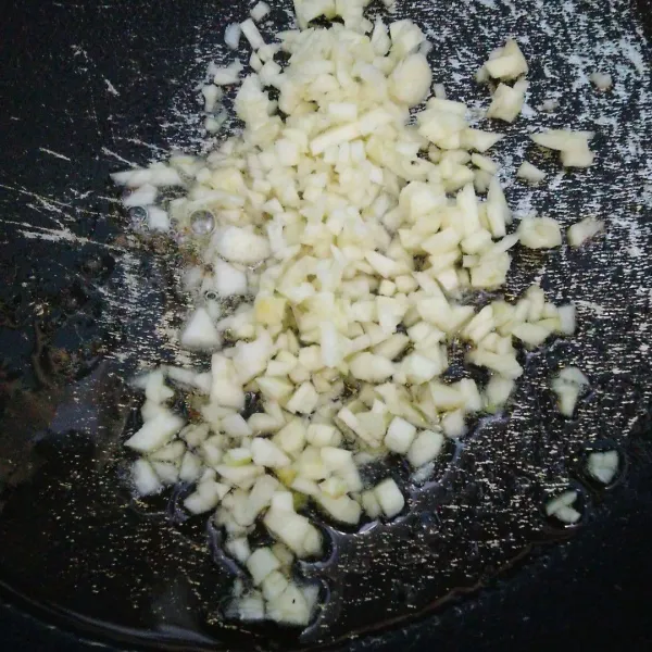 Siapkan wajan atau teflon, beri sedikit minyak. Tumis bawang putih hingga kekuningan.
