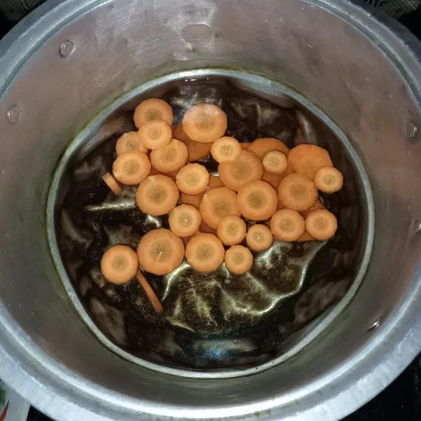 Masukkan air dan wortel ke dalam panci, lalu masak hingga mendidih.