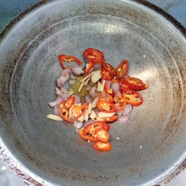 Tumis bawang merah, bawang putih, cabai merah dan cabai rawit sampai harum dan layu.