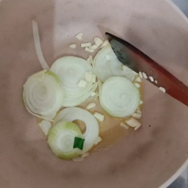 Panaskan mentega, tumis bombay dan bawang putih hingga harum.