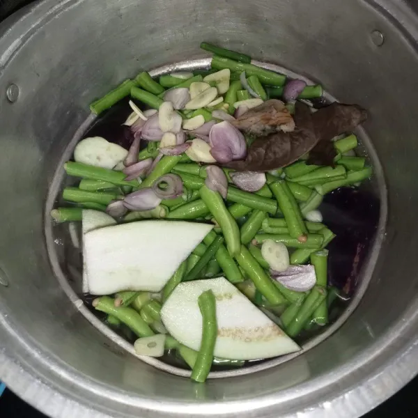 Masukkan terong, kacang panjang, lengkuas, daun salam, bawang merah dan bawang putih.