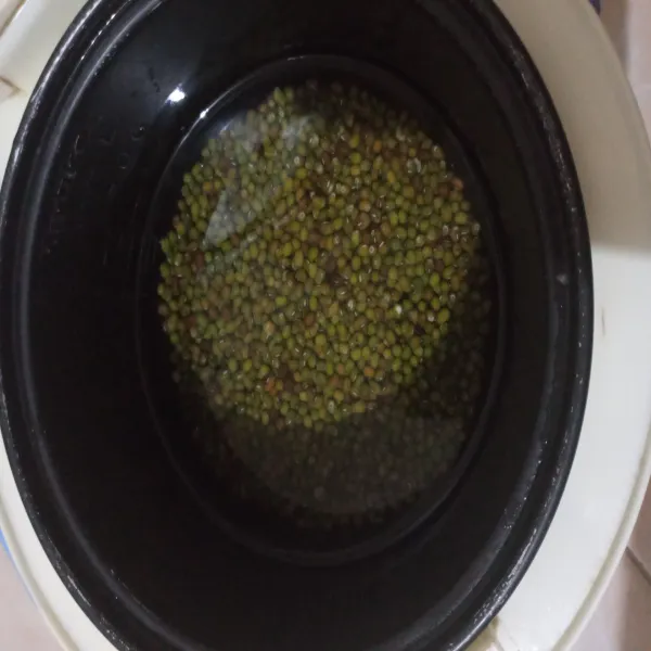 Masukkan air dan kacang hijau kedalam rice cooker, jika ada daun pandan bisa ditambahkan agar lebih wangi aromanya.