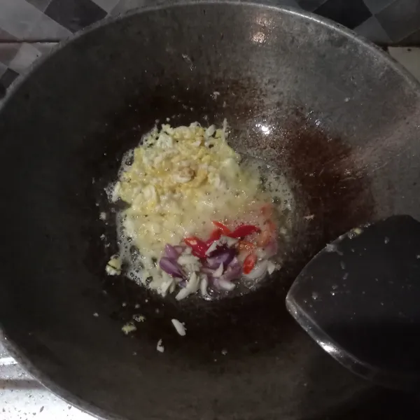 Masukkan irisan bawang putih, bawang merah, dan cabe. Aduk rata dan masak sampai tercium aroma harum bawang.