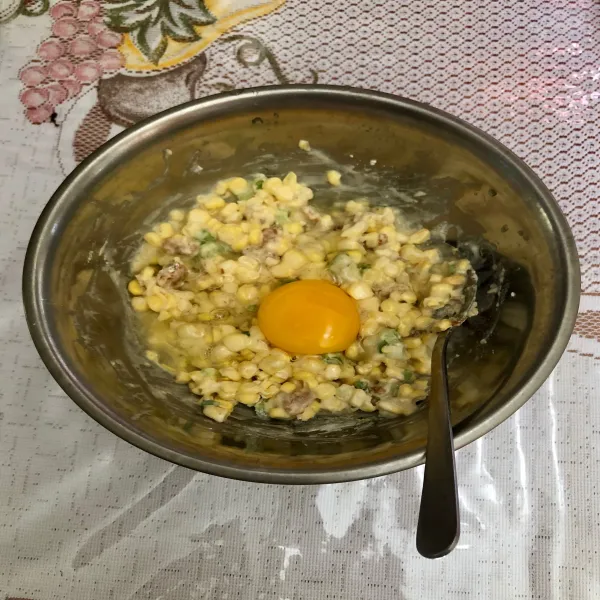 Masukkan satu butir telur ayam lalu aduk hingga rata.