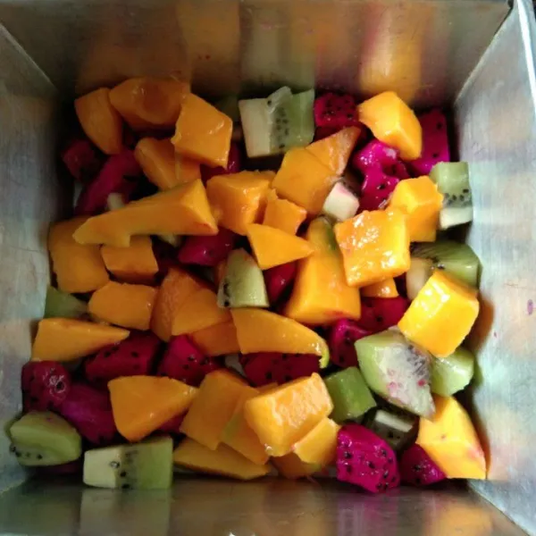 Siapkan cetakan yang sudah di tata potongan buah kiwi, buah naga dan buah mangga.
