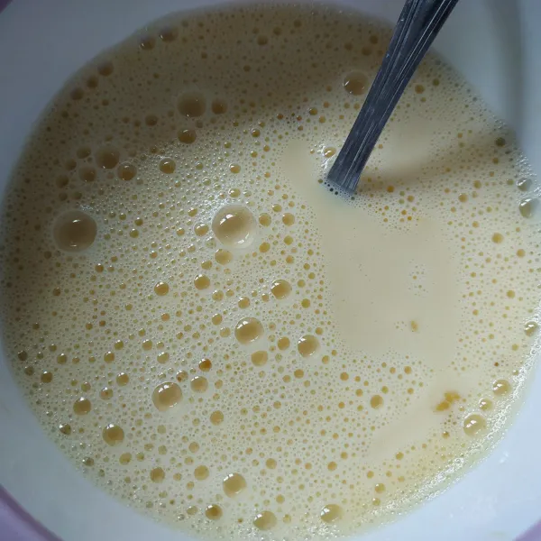 Masukan sedikit susu cair ke dalam telur sambil terus diaduk, tambahkan sisa susu aduk hingga tercampur rata.