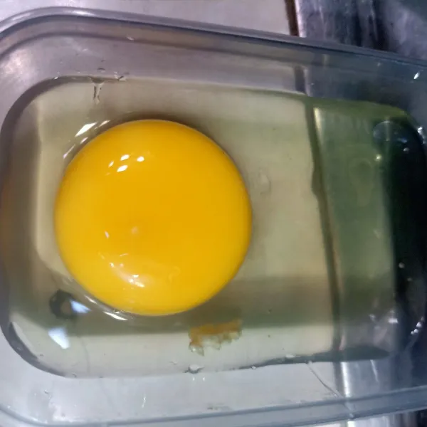 Pecahkan telur ayam ke dalam wadah