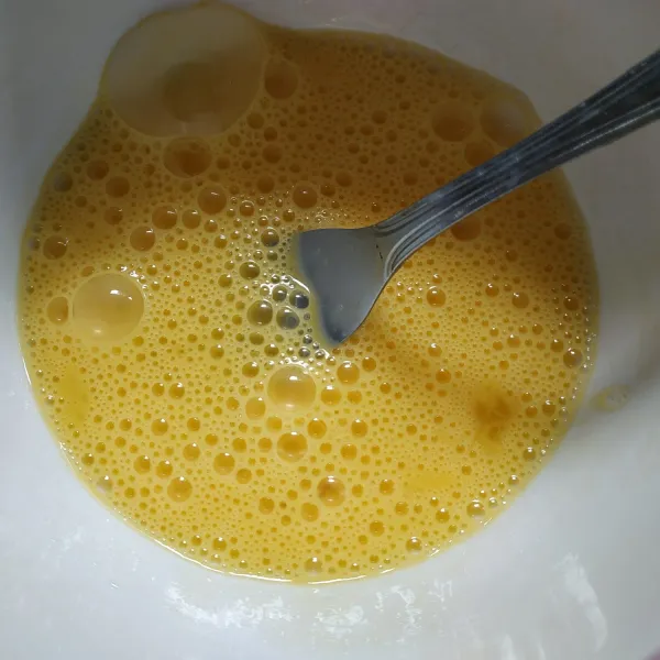 Kocok lepas telur menggunakan garpu.
