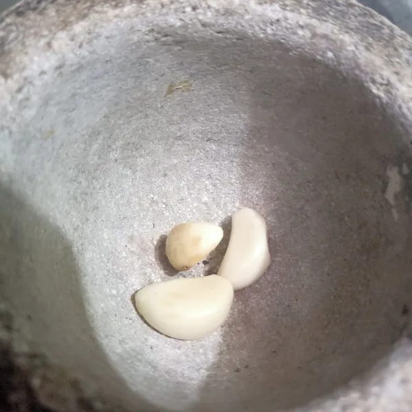 Kupas kulit bawang putih lalu bawang putih masukan ke dalam cobek