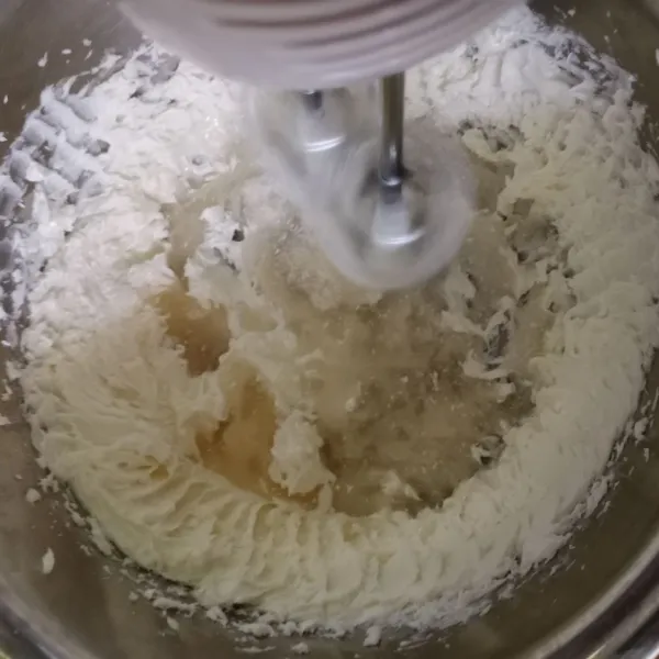 Kemudian masukan sedikit demi sedikit gula halus yang sudah dilarutkan dengan air, mixer dengan kecepatan tinggi sampai rata.