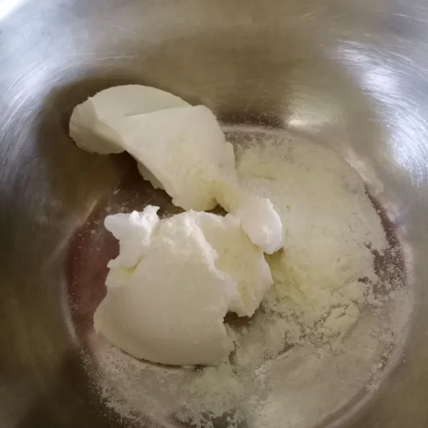 Campur mentega putih dan susu bubuk di dalam wadah.