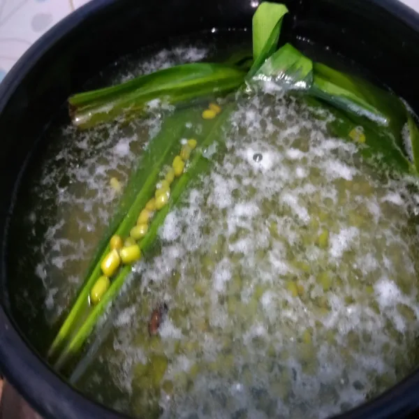 Rebus kacang hijau dengan 1,5 iiter air. Beri daun pandan. Rebus hingga setengah empuk. Matikan api. Lalu buang air rebusannya.