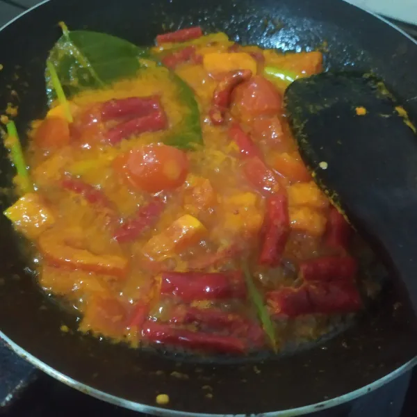 Panaskan minyak, tumis bumbu, salam, serai, hingga harum, lalu masukkan irisan tomat dan cabai, aduk rata.