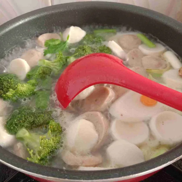 Tambahkan garam, gula, kaldu bubuk, lada bubuk, dan pala bubuk, biarkan mendidih, kemudian masukkan brokoli. Aduk rata.