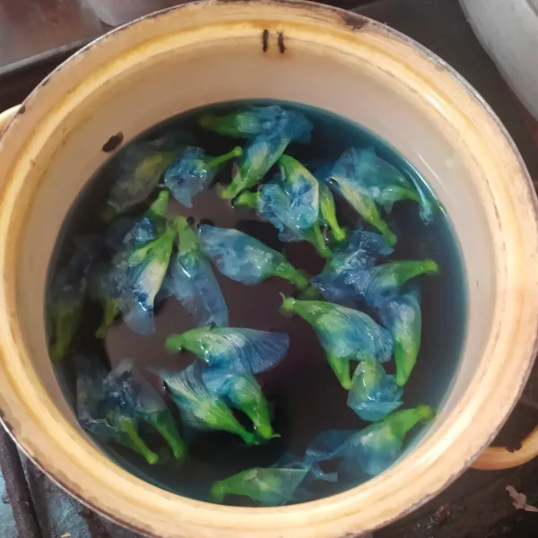 Masukkan air dan bunga telang. Rebus hingga airnya berwarna biru, lalu saring dan takar sebanyak 500 ml.