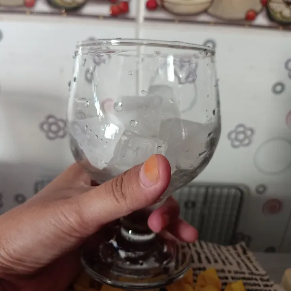 Masukkan es batu dalam gelas saji