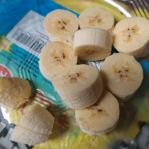 Kupas pisang, lalu potong menjadi beberapa bagian.
