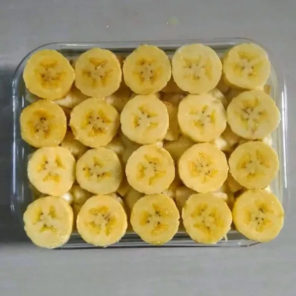 Tambahkan potongan pisang, lapisan pisang yang ketiga, yang paling atas.