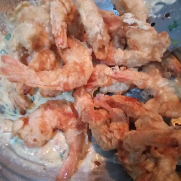 Masukkan udang goreng tepung ke dalam saus telur asin. Matikan api. Aduk cepat. Angkat dan hidangkan.