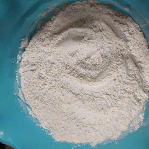 Larutkan 1 sachet Indomilk Kental Manis Putih dengan air putih matang. Campur rata tepung beras ketan, tepung terigu, gula pasir, baking powder dan garam halus, aduk rata.