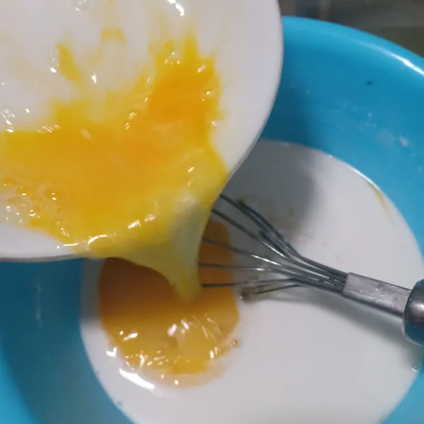 Kocok telur dalam wadah lain lalu campurkan.