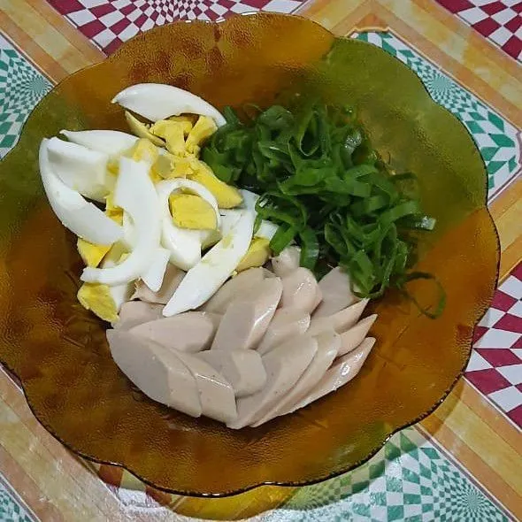 Potong-potong sosis, telur, dan daun bawang.