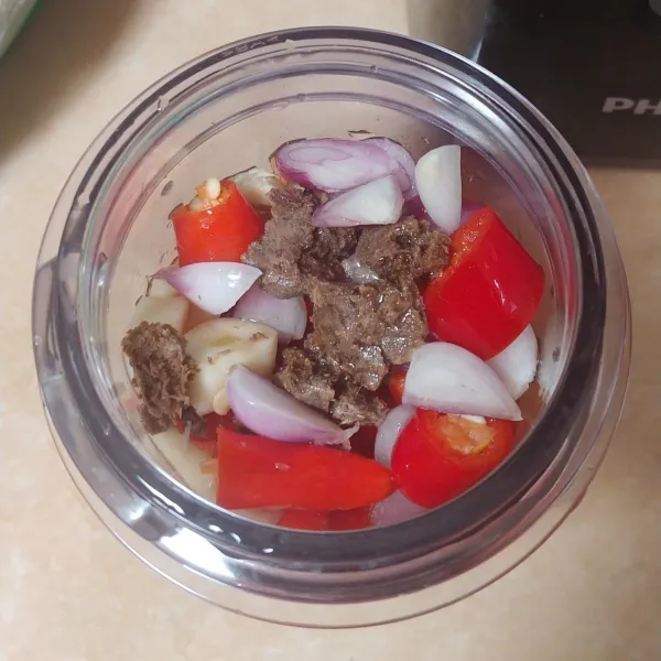 Potong kecil lalu masukkan ke dalam gelas blender. Tambahkan terasi dan minyak goreng.