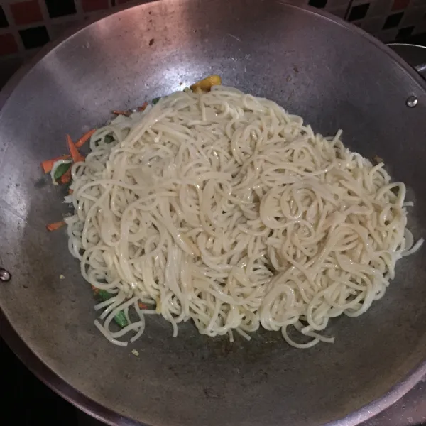 Masukkan mie, dan tambahkan kecap manis, aduk rata, koreksi rasa.