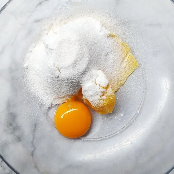 Masukan mentega, kuning telur, dan gula halus. Mixer hingga lembut.