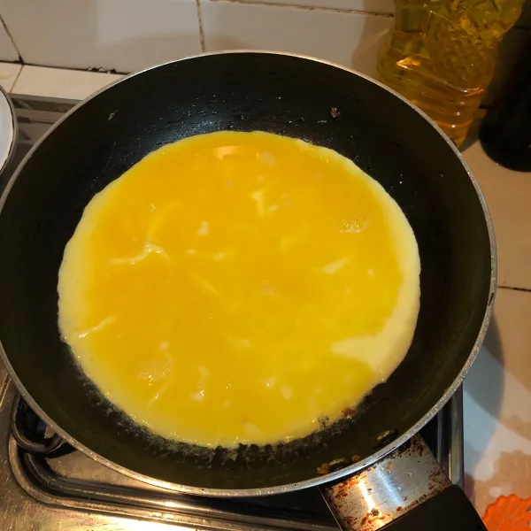 Goreng telur di api kecil.