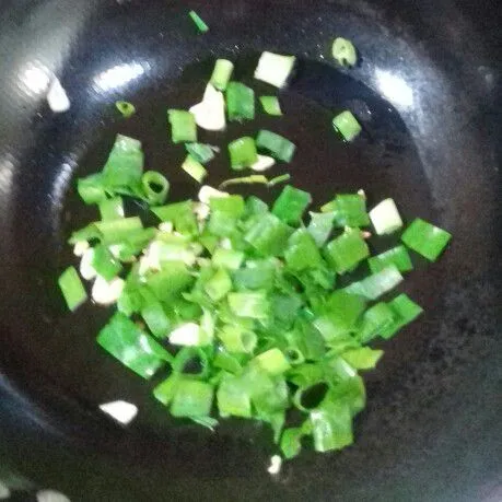 Panaskan sedikit minyak goreng, lalu tumis bawang putih dan daun bawang hingga layu dan wangi.