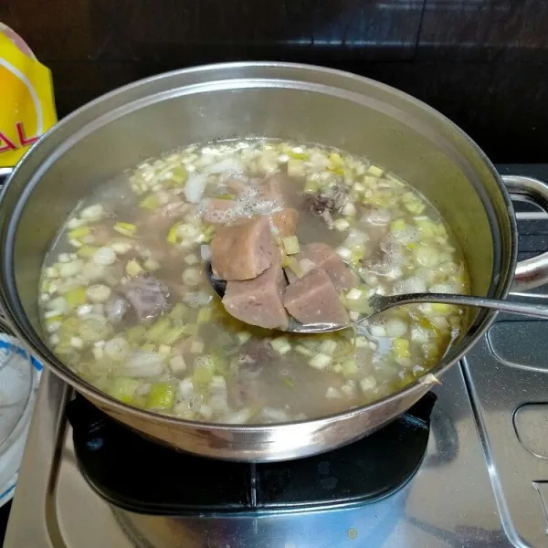 Setelah satu jam, masukkan bumbu halus, bawang bombay dan bakso ke rebusan tulang ayam. Tunggu hingga harum dan matang.