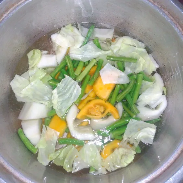 Didihkan air secukupnya, masukkan sayuran, masak sebentar sampai sayuran setengah matang.