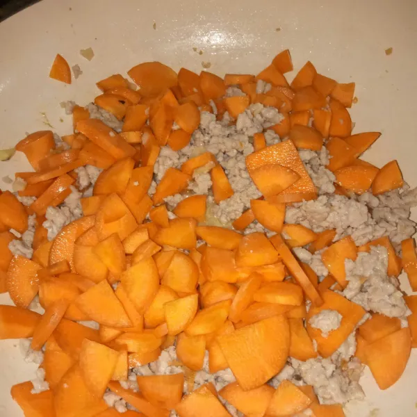 Masukkan wortel, aduk rata, masak hingga wortel agak layu.