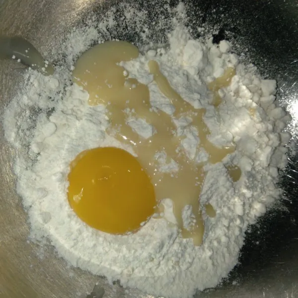 Dalam wadah, masukkan tepung terigu, kuning telur dan susu kental manis.