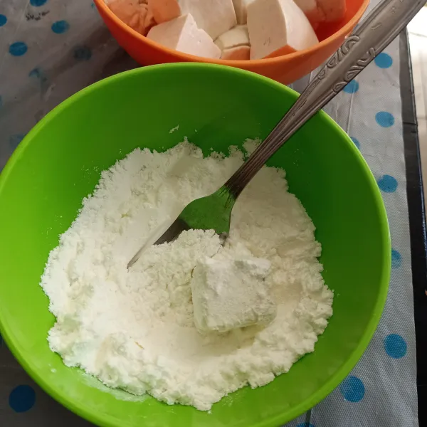 Lumuri tahu dengan tepung satu per satu.