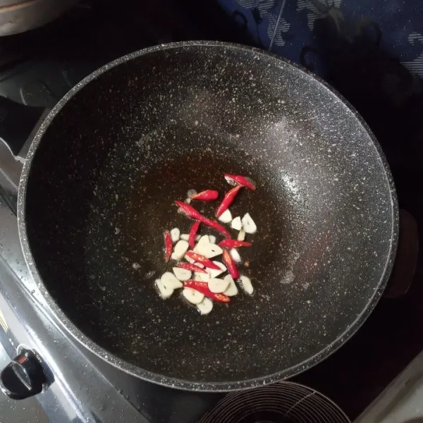 Panaskan minyak, tumis bawang putih dan cabe merah hingga layu.