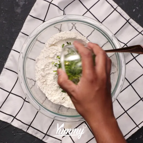 Tambahkan daun bawang, perasan kunyit, air dan telur ke dalamnya lalu aduk hingga tercampur rata.