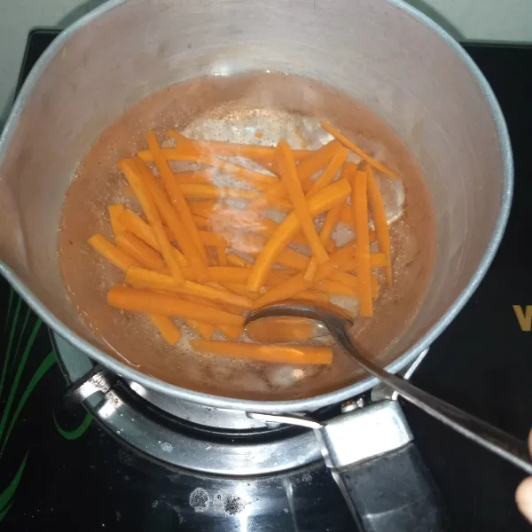 Rebus air hingga mendidih, tambahkan garam. Aduk rata, masukkan wortel masak hingga matang tiriskan.