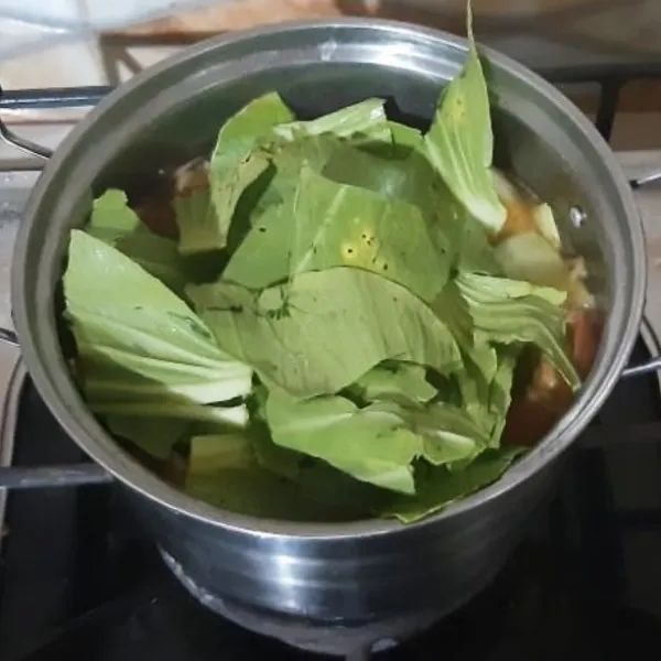 Masukan daun pakcoy. Aduk rata. Masak sebentar hingga daun pakcoy layu. Angkat.