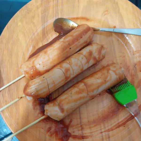 Olesi sosis dengan bumbu bbq menggunakan kuas sambil dibolak-balik.