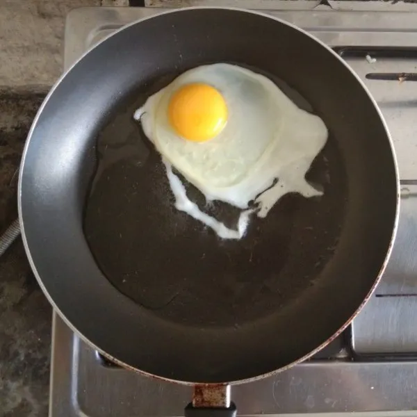 Goreng telur ceplok. Tambahkan di atas nasi goreng setelahnya.