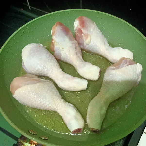 Siapkan wajan lalu masukkan minyak goreng sedikit lalu setelah panas, masukkan paha ayam. Goreng setengah matang. Lalu angkat.