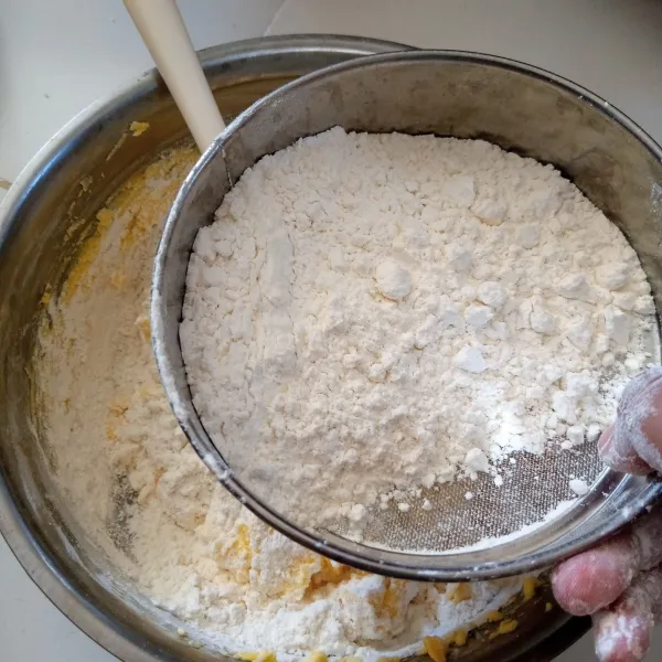 Campur maizena, tepung terigu dan susu menjadi satu kemudian ayak kedalam campuran butter dan keju.